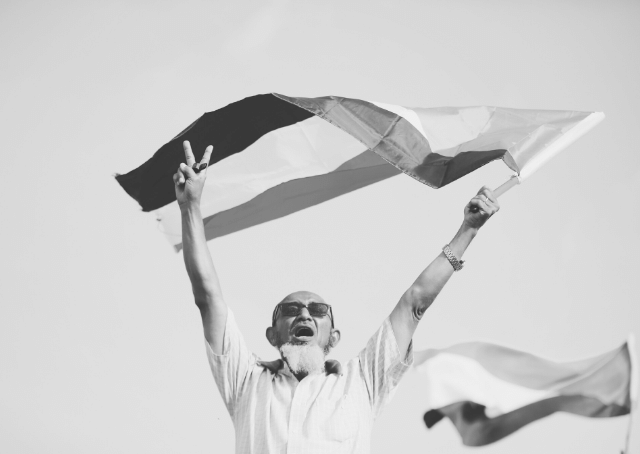 Homme brandissant le drapeau soudanais